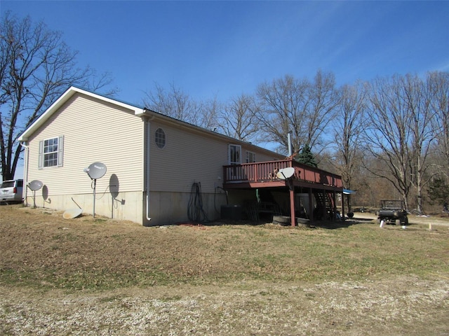 back of house featuring a wooden deck and a lawn