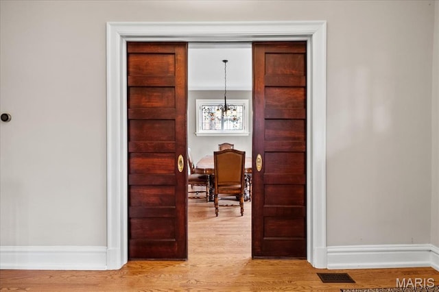 6230 Waterman Ave, Saint Louis, MO 63130 - dining room featuring light wood-style floors, a chandelier, and baseboards