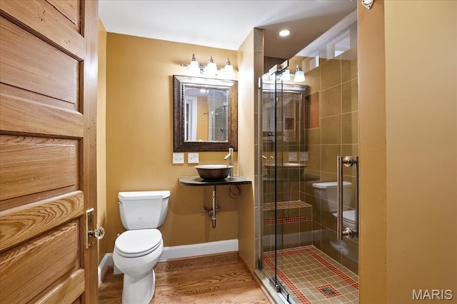 6230 Waterman Ave, Saint Louis, MO 63130 - bathroom with toilet, a stall shower, a sink, baseboards, and wood finished floors