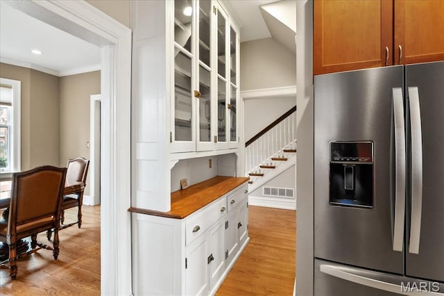 6230 Waterman Ave, Saint Louis, MO 63130 - kitchen with stainless steel fridge, glass insert cabinets, ornamental molding, light wood-style floors, and recessed lighting