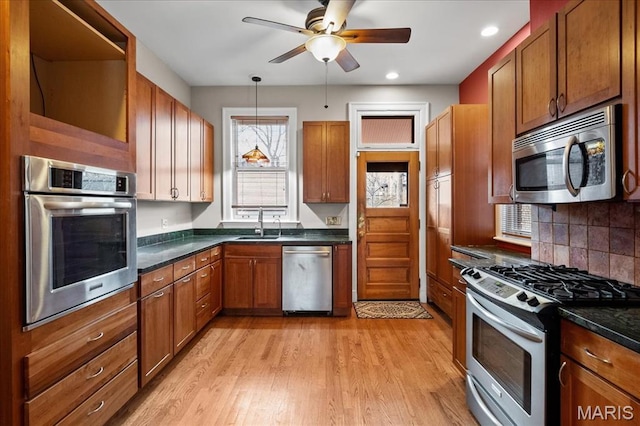 6230 Waterman Ave, Saint Louis, MO 63130 - kitchen with stainless steel appliances, dark countertops, open shelves, a ceiling fan, and light wood-type flooring