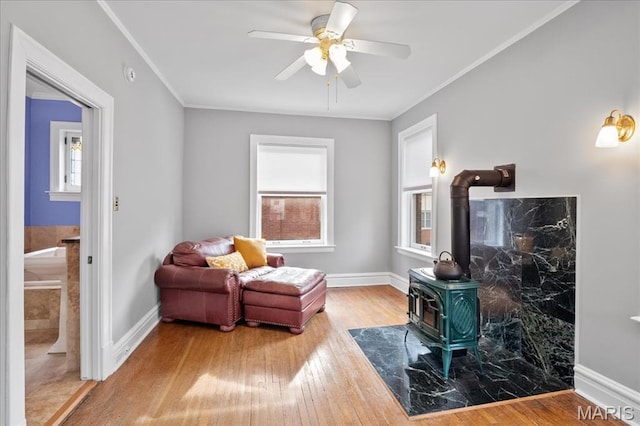 6230 Waterman Ave, Saint Louis, MO 63130 - sitting room with a wood stove, plenty of natural light, a ceiling fan, wood finished floors, and ornamental molding