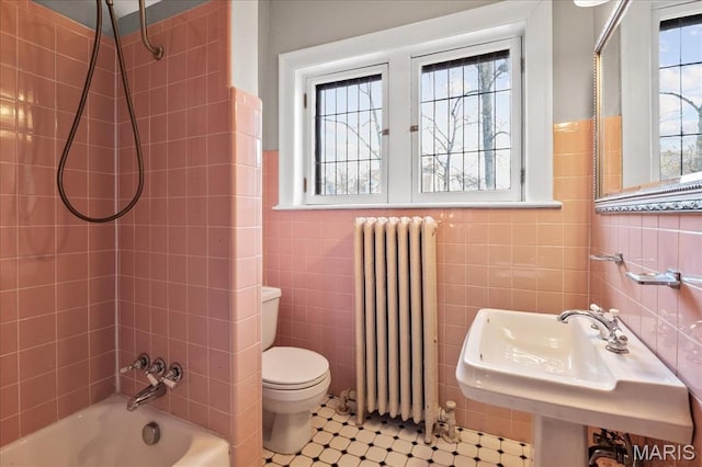 6230 Waterman Ave, Saint Louis, MO 63130 - bathroom featuring radiator, tile walls, tub / shower combination, toilet, and a sink