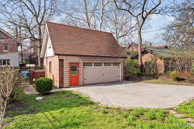 6230 Waterman Ave, Saint Louis, MO 63130 - view of property exterior with an outbuilding, a garage, a shingled roof, and fence