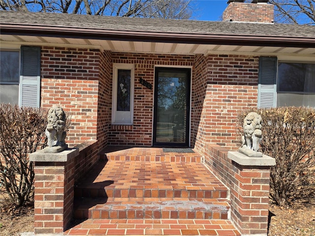 400 Smith Rd, Lebanon, MO 65536 - view of exterior entry with brick siding, a chimney, and a shingled roof