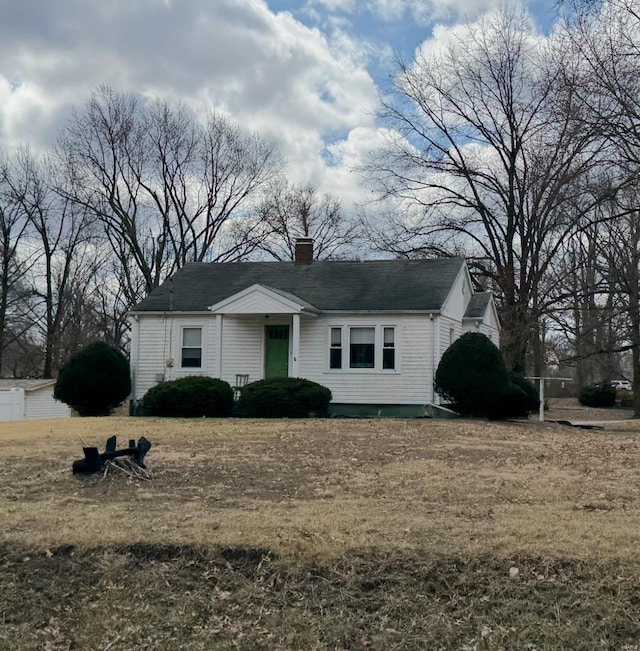 view of front of house with a chimney and a front lawn