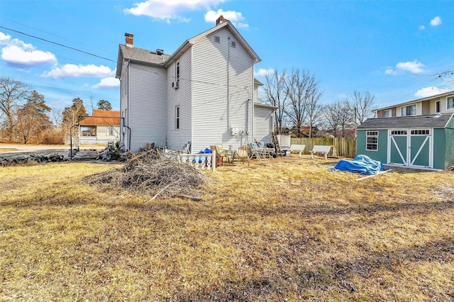 105 W Ave, Eureka, MO 63025 - rear view of house with a chimney, an outdoor structure, a lawn, and a storage unit