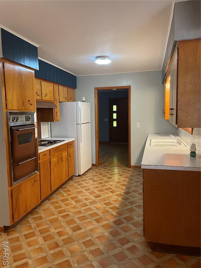1415 Woodland Rd, Poplar Bluff, MO 63901 - kitchen featuring oven, a sink, a warming drawer, light countertops, and under cabinet range hood