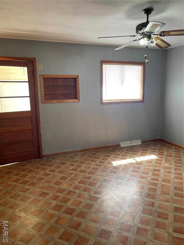 1415 Woodland Rd, Poplar Bluff, MO 63901 - unfurnished room featuring light flooring, ceiling fan, baseboards, and wood walls