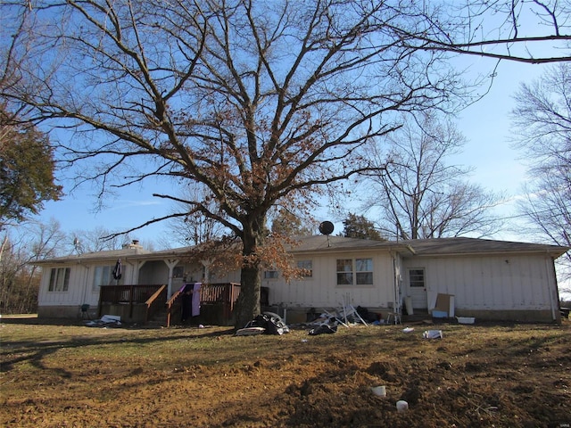 rear view of house with a chimney, board and batten siding, and a yard