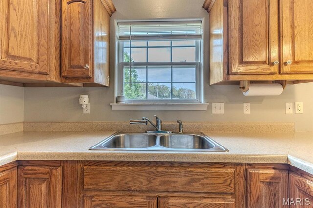 kitchen with a sink, brown cabinetry, and light countertops