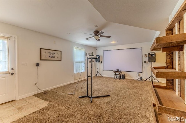 workout room featuring a ceiling fan, carpet flooring, tile patterned flooring, and baseboards