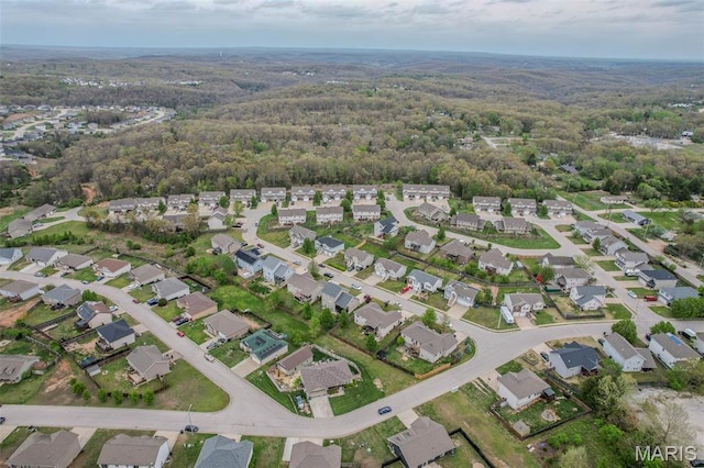 view of property location with a forest and nearby suburban area