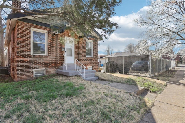 4644 Minnesota Ave, Saint Louis, MO 63111 - view of front of home featuring fence, brick siding, and a chimney