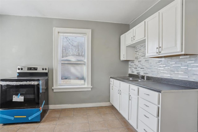4644 Minnesota Ave, Saint Louis, MO 63111 - kitchen with electric stove, dark countertops, backsplash, and white cabinets