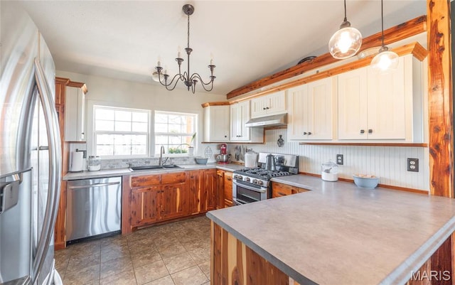 5819 Highway Vv Hwy, Vv, MO 65542 - kitchen with stainless steel appliances, a sink, under cabinet range hood, a peninsula, and hanging light fixtures