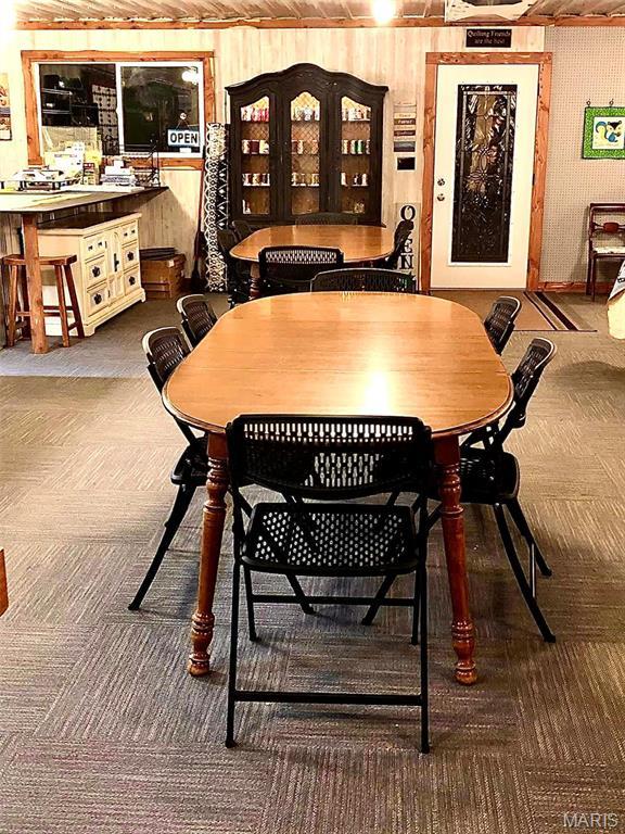 504 Alvarado Ave, Belle, MO 65013 - carpeted dining space with wood walls