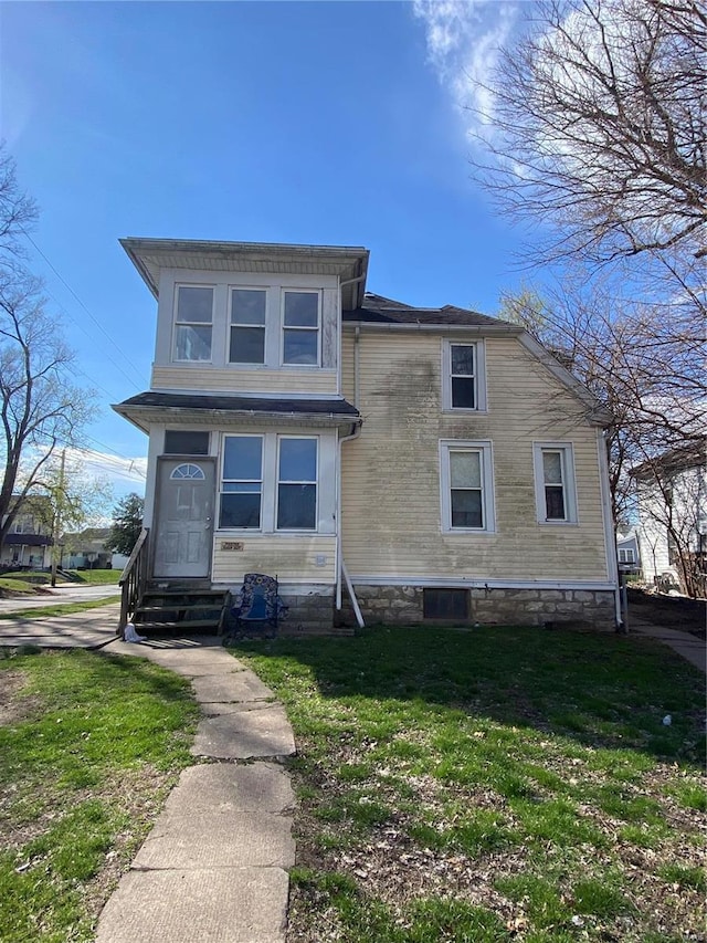 view of front of house featuring entry steps and a front yard