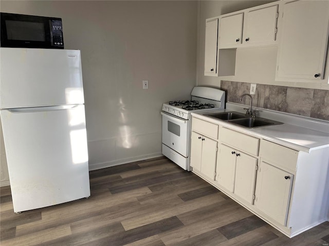 kitchen with white appliances, a sink, white cabinets, dark wood-style flooring, and light countertops