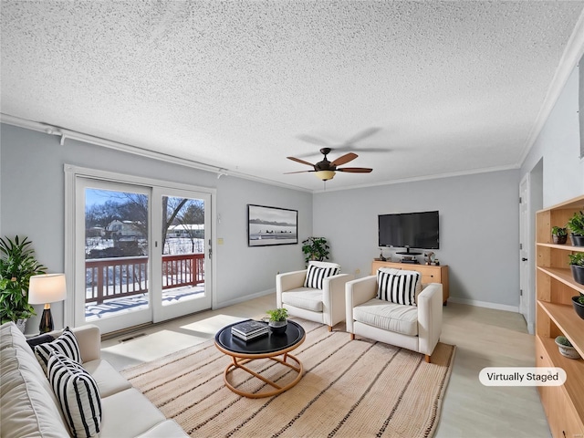 living room featuring a textured ceiling, ceiling fan, ornamental molding, light wood-type flooring, and baseboards
