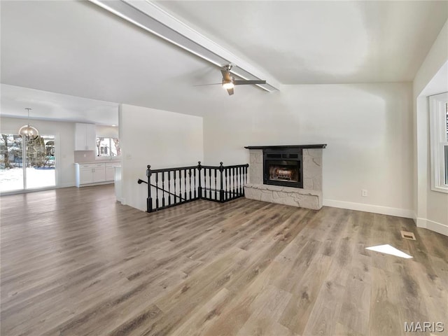 38 N Lang Dr, Ofallon, MO 63366 - living room with light wood finished floors, a stone fireplace, a chandelier, and ceiling fan