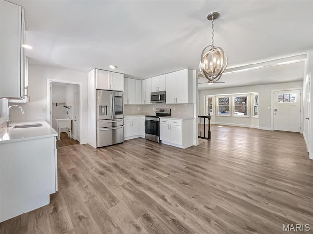 38 N Lang Dr, Ofallon, MO 63366 - kitchen with appliances with stainless steel finishes, a chandelier, open floor plan, light countertops, and recessed lighting