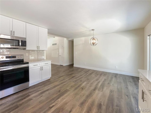 38 N Lang Dr, Ofallon, MO 63366 - kitchen with stainless steel appliances, light countertops, backsplash, a chandelier, and white cabinetry