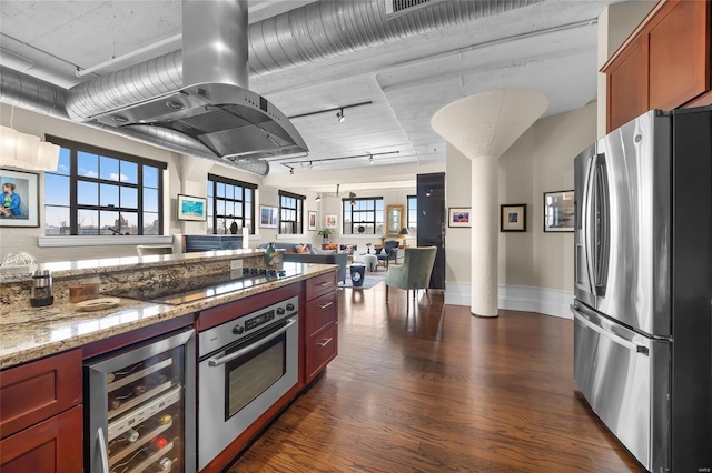 kitchen with stainless steel appliances, beverage cooler, island range hood, dark wood-style flooring, and light stone countertops