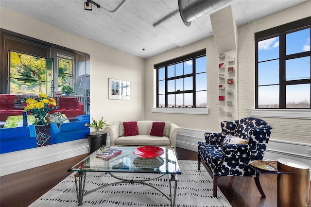 living area featuring wood finished floors, plenty of natural light, and baseboards