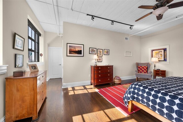 bedroom with rail lighting, baseboards, wood finished floors, and ceiling fan