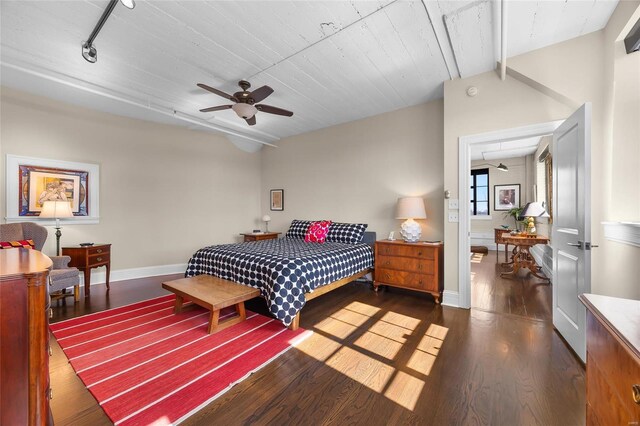 bedroom featuring wood finished floors, baseboards, vaulted ceiling, and a ceiling fan