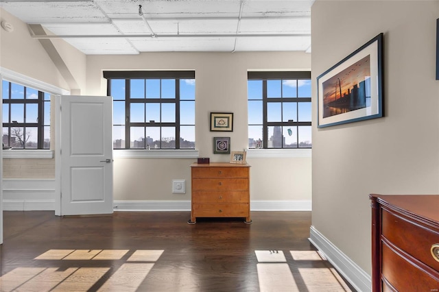 doorway to outside with wood finished floors, plenty of natural light, and baseboards