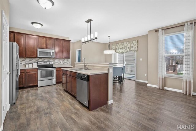 1705 Belleau Wood Dr, Saint Peters, MO 63376 - kitchen with appliances with stainless steel finishes, a sink, dark wood-style flooring, and tasteful backsplash