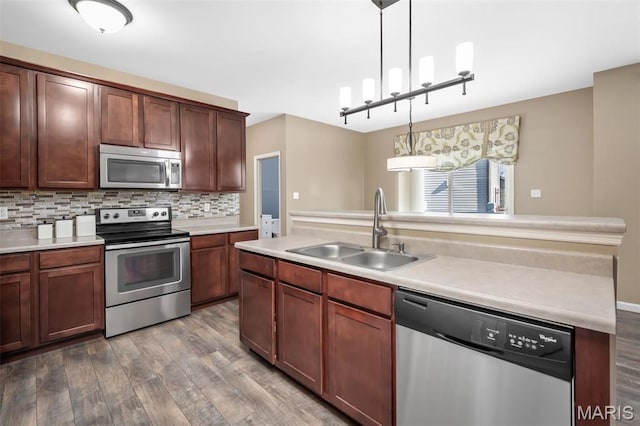 1705 Belleau Wood Dr, Saint Peters, MO 63376 - kitchen featuring stainless steel appliances, a sink, wood finished floors, decorative light fixtures, and light countertops