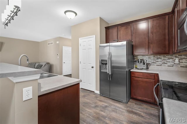 1705 Belleau Wood Dr, Saint Peters, MO 63376 - kitchen with appliances with stainless steel finishes, wood finished floors, light countertops, and backsplash