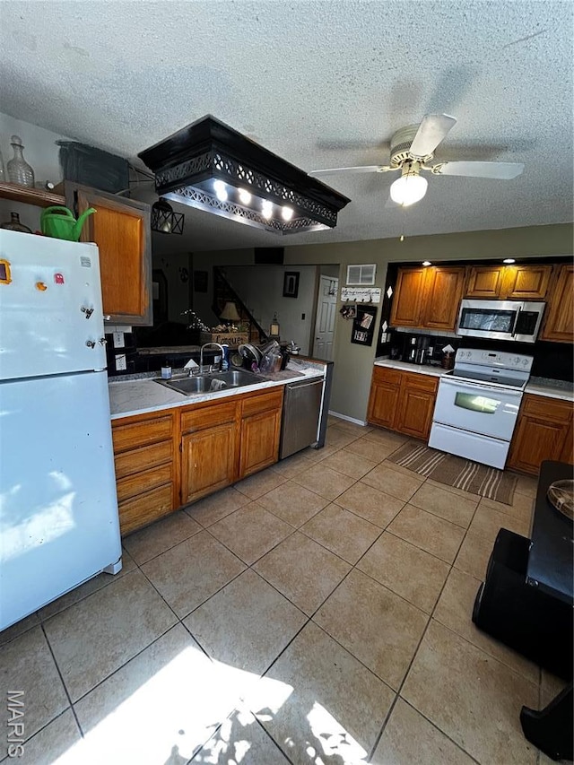 338 Mont Pellier St, Bonne Terre, MO 63628 - kitchen with white appliances, light tile patterned floors, light countertops, brown cabinetry, and a sink
