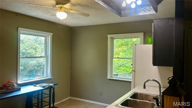338 Mont Pellier St, Bonne Terre, MO 63628 - kitchen featuring a sink, a textured ceiling, light tile patterned flooring, ceiling fan, and light countertops