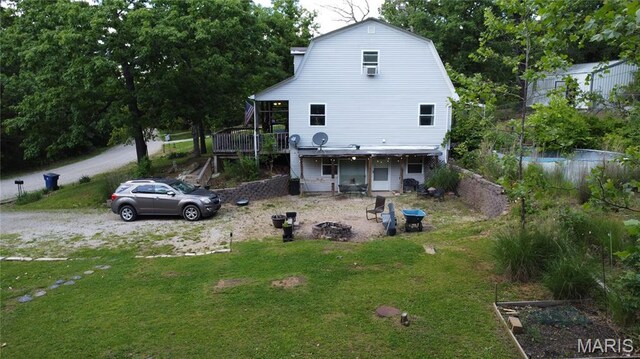 338 Mont Pellier St, Bonne Terre, MO 63628 - back of house with a lawn, a gambrel roof, a wooden deck, and an outdoor fire pit