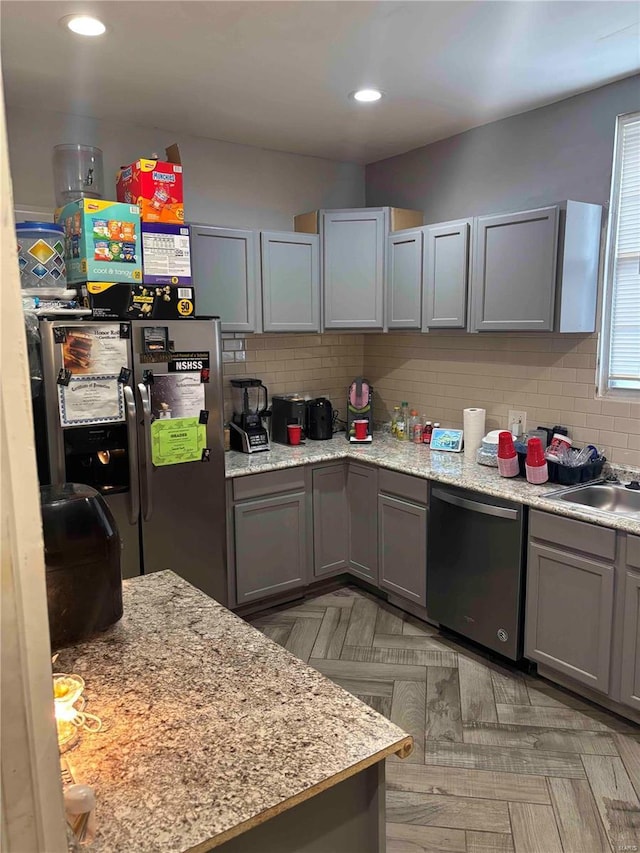 2803 Semple Ave, Saint Louis, MO 63120 - kitchen with stainless steel dishwasher, refrigerator with ice dispenser, gray cabinets, tasteful backsplash, and a sink