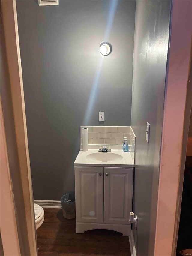 2803 Semple Ave, Saint Louis, MO 63120 - half bath with tasteful backsplash, toilet, wood finished floors, and vanity