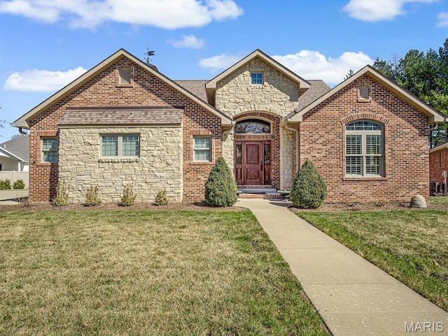 103 Evergreen Ct, Waterloo, IL 62298 - french provincial home with stone siding, a front yard, roof with shingles, and brick siding