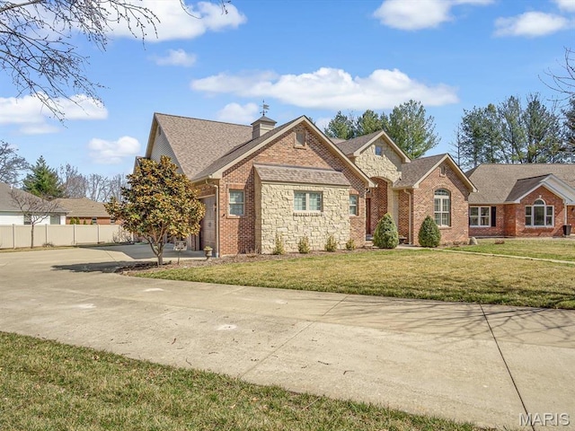 103 Evergreen Ct, Waterloo, IL 62298 - traditional-style house with concrete driveway, stone siding, a chimney, a shingled roof, and brick siding