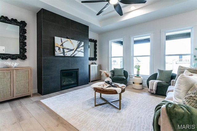 1519 Oglesby Dr, Edwardsville, IL 62025 - living area featuring light wood-type flooring, ceiling fan, a tile fireplace, and a tray ceiling