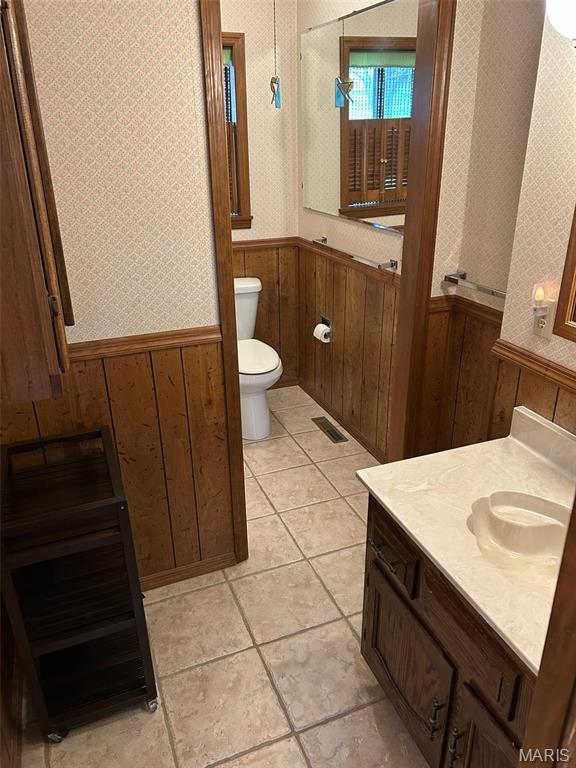 266 Hunt Club Cir, Galena, MO 65656 - bathroom with wainscoting, wooden walls, toilet, tile patterned flooring, and vanity