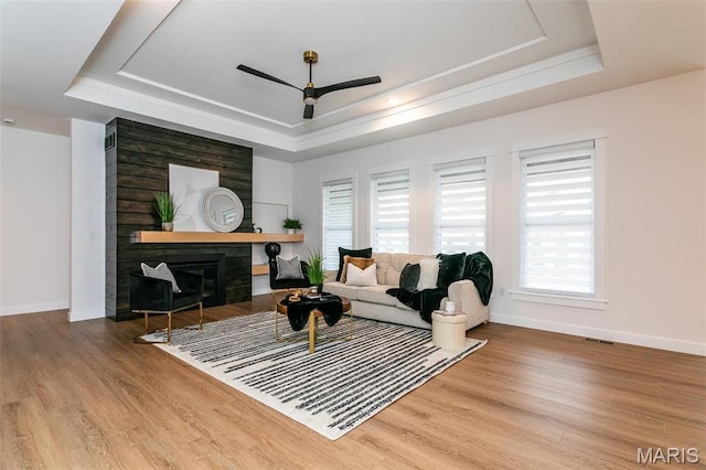 1511 Oglesby Dr, Edwardsville, IL 62025 - living room featuring a tray ceiling, ceiling fan, wood finished floors, and a glass covered fireplace