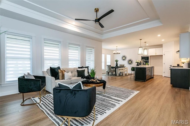1511 Oglesby Dr, Edwardsville, IL 62025 - living room featuring a tray ceiling, ceiling fan, light wood-style flooring, a chandelier, and recessed lighting