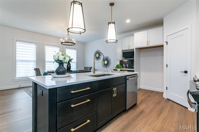 1511 Oglesby Dr, Edwardsville, IL 62025 - kitchen with stainless steel appliances, light countertops, a center island with sink, light wood-style floors, and recessed lighting
