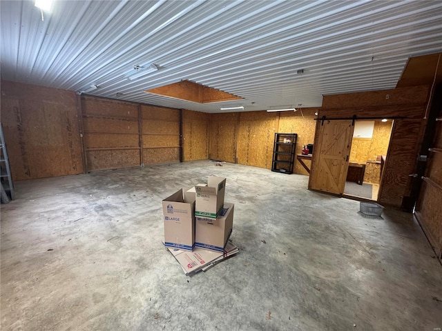 9 Summit Ln, Hermann, MO 65041 - miscellaneous room featuring a garage, unfinished concrete flooring, and a barn door