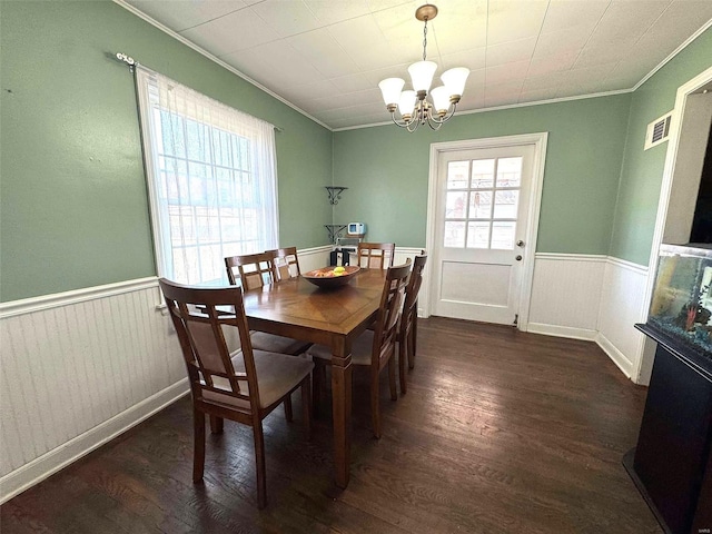 dining room featuring crown molding, a chandelier, wainscoting, and dark wood finished floors