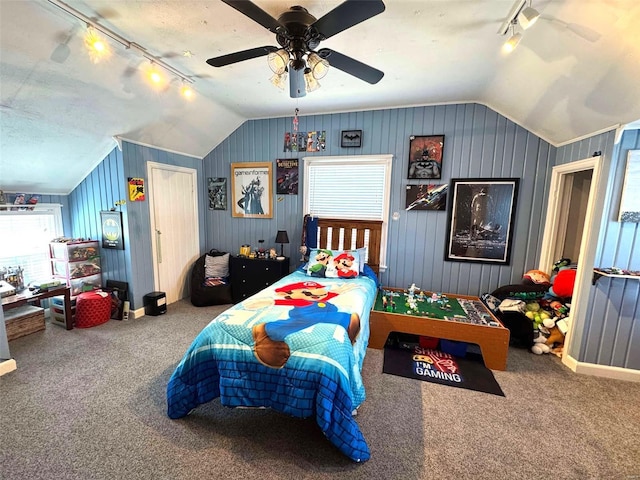 carpeted bedroom featuring rail lighting, vaulted ceiling, and ceiling fan